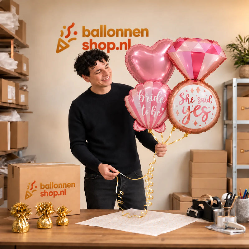 Jesse houdt She Said Yes XL Trosje Ballonnen vast in de warme werkplaats van Ballonnenshop.nl.