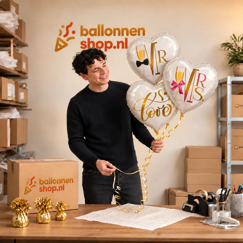 Jesse houdt Mr & Mrs Love Trosje Ballonnen vast in de warme werkplaats van Ballonnenshop.nl.