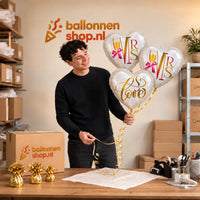 Jesse houdt Mrs & Mrs Love Trosje Ballonnen vast in de warme werkplaats van Ballonnenshop.nl.
