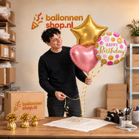 Jesse houdt Happy Birthday Roze/Goud/Wit Tros vast in de warme werkplaats van Ballonnenshop.nl.