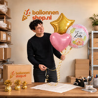 Jesse houdt Ik Word Grote Zus Trosje vast in de warme werkplaats van Ballonnenshop.nl.