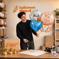 Jesse houdt Ik Word Grote Broer Trosje vast in de warme werkplaats van Ballonnenshop.nl.