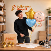 Jesse houdt Baby Trosje Ballonnen Blauw vast in de warme werkplaats van Ballonnenshop.nl.