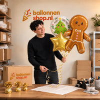 Jesse houdt Peperkoekmannetje XL Trosje vast in de warme werkplaats van Ballonnenshop.nl.
