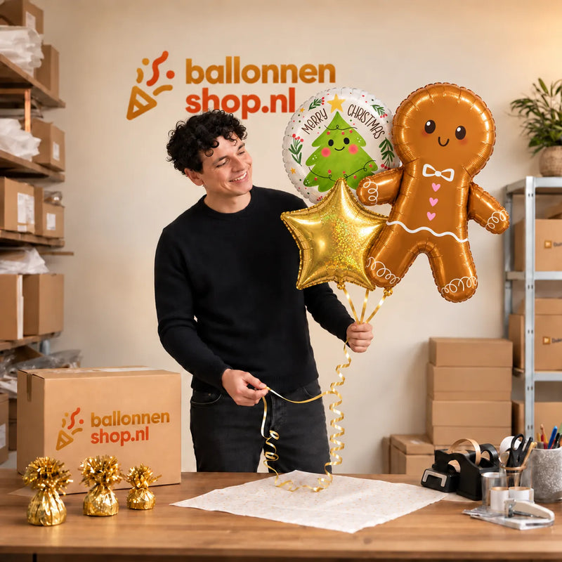Jesse houdt Peperkoekmannetje XL Trosje vast in de warme werkplaats van Ballonnenshop.nl.