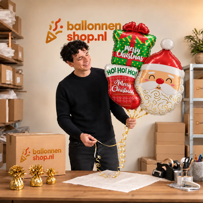 Jesse houdt Kerstman Trosje Helium Ballonnen vast in de warme werkplaats van Ballonnenshop.nl.