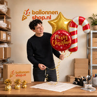 Jesse houdt Kerst XL Trosje Helium Ballonnen vast in de warme werkplaats van Ballonnenshop.nl.