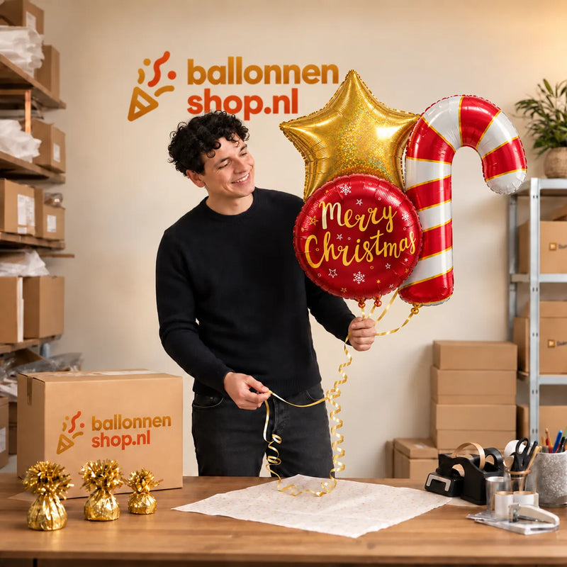 Jesse houdt Kerst XL Trosje Helium Ballonnen vast in de warme werkplaats van Ballonnenshop.nl.