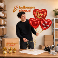 Jesse houdt Ballonnentros Ik Hou Van Jou – Dit is geven met Liefde vast in de warme werkplaats van Ballonnenshop.nl.