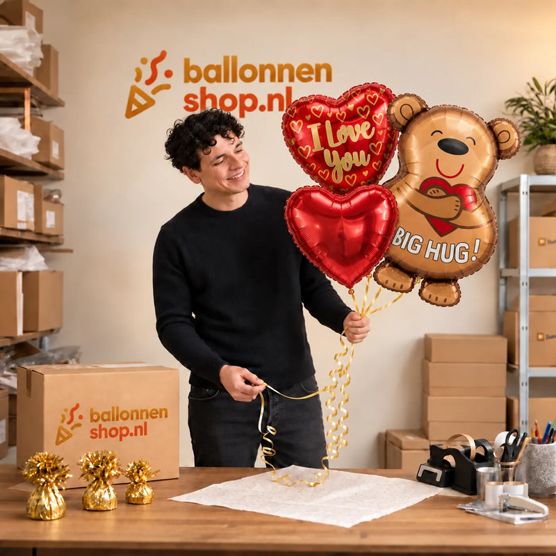 Jesse houdt Big Hug Ballonnentros vast in de warme werkplaats van Ballonnenshop.nl.