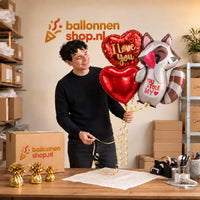 Jesse houdt You Stole My Heart Ballonnentros vast in de warme werkplaats van Ballonnenshop.nl.