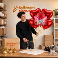 Jesse houdt XL I Love You Cadeau Ballonnentros 5 Ballonnen vast in de warme werkplaats van Ballonnenshop.nl.