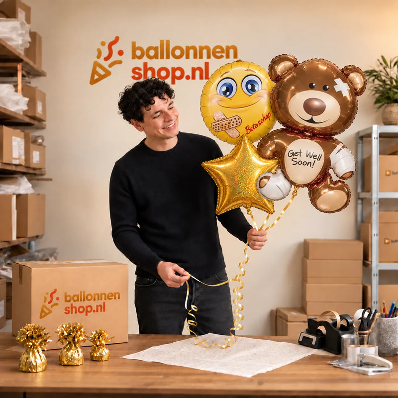 Jesse houdt Get Well Soon Beer XL Trosje vast in de warme werkplaats van Ballonnenshop.nl.