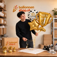 Jesse houdt Geslaagd Trofee Ballonnentros vast in de warme werkplaats van Ballonnenshop.nl.