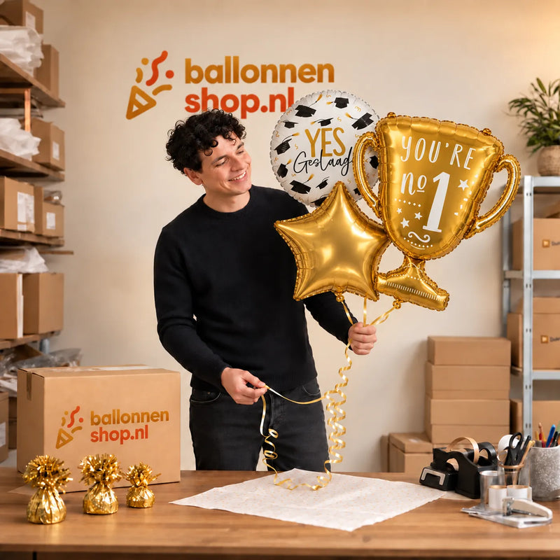 Jesse houdt Geslaagd Trofee Ballonnentros vast in de warme werkplaats van Ballonnenshop.nl.
