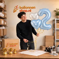 Jesse houdt 2 Jaar Pastelblauw Hartjes Tros vast in de warme werkplaats van Ballonnenshop.nl.