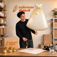 Jesse houdt de Trouwjurk Helium XL Ballon vast in de warme inpakruimte van Ballonnenshop.nl.