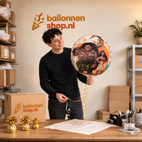Jesse houdt de Vaiana En Maui Helium Ballon vast in de warme inpakruimte van Ballonnenshop.nl.