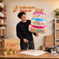 Jesse houdt de Verjaardagstaart Helium Ballon vast in de warme inpakruimte van Ballonnenshop.nl.