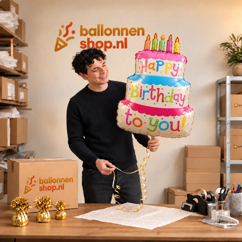 Jesse houdt de Verjaardagstaart Helium Ballon vast in de warme inpakruimte van Ballonnenshop.nl.