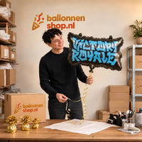 Jesse houdt de Victory Royale Helium Ballon vast in de warme inpakruimte van Ballonnenshop.nl.