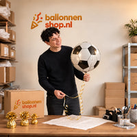 Jesse houdt de Voetbal Helium Ballon 3D vast in de warme inpakruimte van Ballonnenshop.nl.