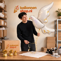 Jesse houdt de Witte Duif Helium XL Ballon vast in de warme inpakruimte van Ballonnenshop.nl.