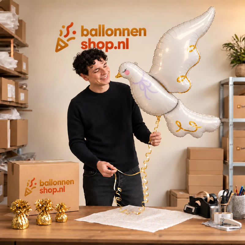 Jesse houdt de Witte Duif Helium XL Ballon vast in de warme inpakruimte van Ballonnenshop.nl.