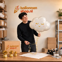 Jesse houdt de Wolk Helium Ballon vast in de warme inpakruimte van Ballonnenshop.nl.
