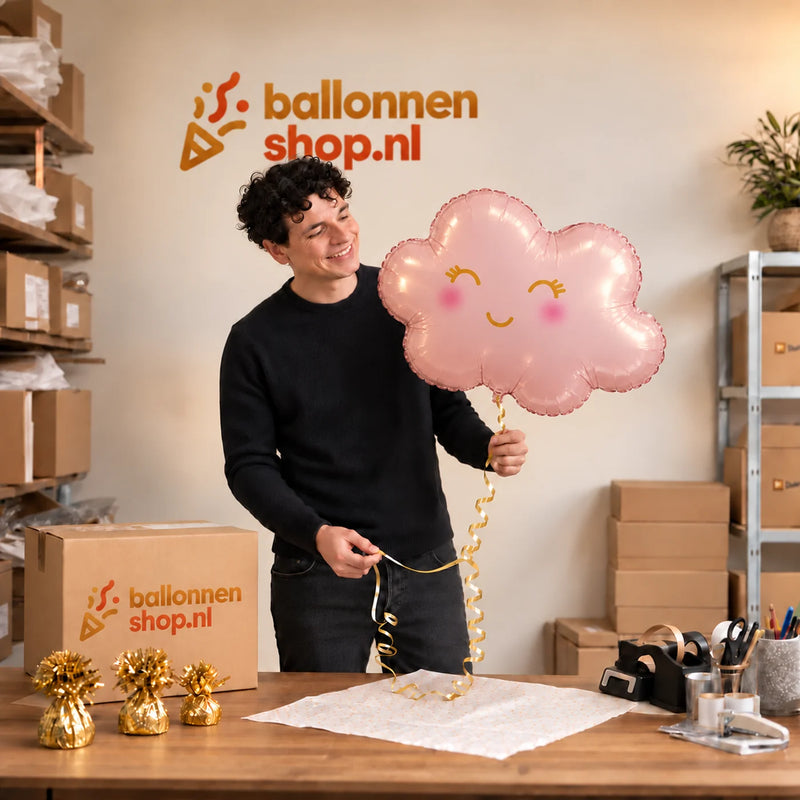 Jesse houdt de Wolk Roze Helium Ballon vast in de warme inpakruimte van Ballonnenshop.nl.