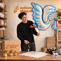 Jesse houdt de Blauwe Ooievaar Helium XL Ballon vast in de warme inpakruimte van Ballonnenshop.nl.
