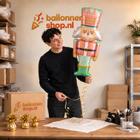 Jesse houdt de Notenkraker Kerst Pastel XL vast in de warme inpakruimte van Ballonnenshop.nl.