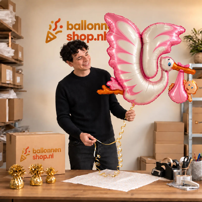 Jesse houdt de Roze Ooievaar XL Ballon vast in de warme inpakruimte van Ballonnenshop.nl.