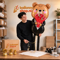 Jesse houdt de XXXL Romantische Beer Met Bloemen Ballon vast in de warme inpakruimte van Ballonnenshop.nl.