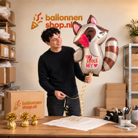 Jesse houdt de You Stole My Heart Wasbeer – Met een Zachte Knipoog vast in de warme inpakruimte van Ballonnenshop.nl.