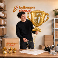 Jesse houdt de You're No.1 Trofee Ballon vast in de warme inpakruimte van Ballonnenshop.nl.