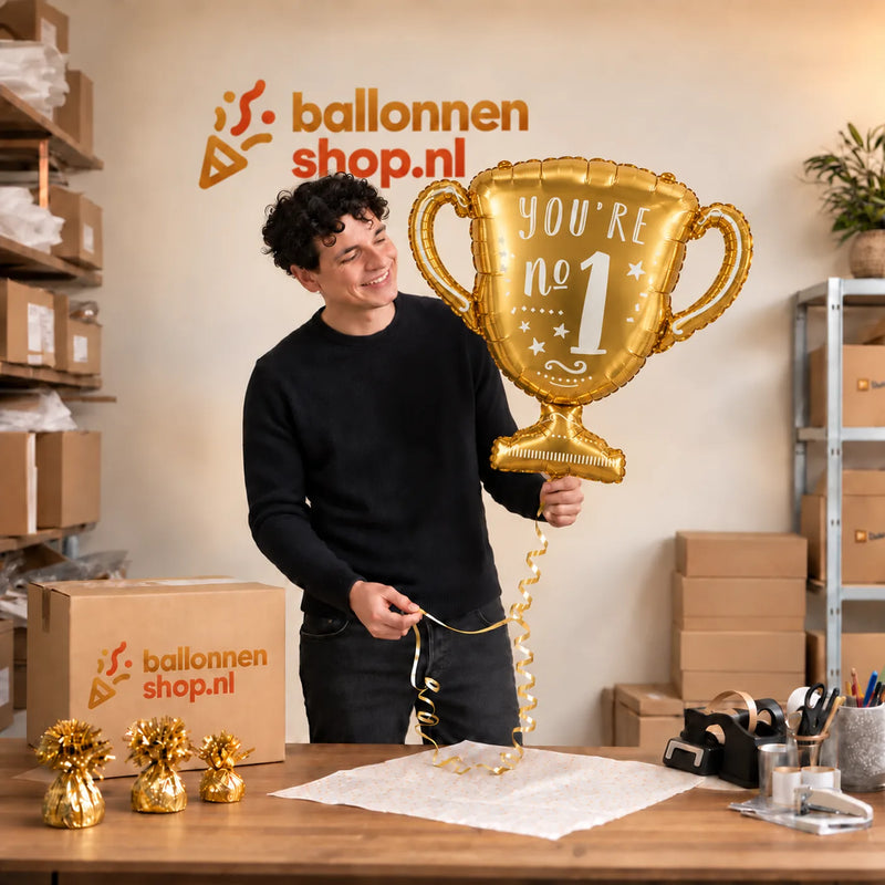 Jesse houdt de You're No.1 Trofee Ballon vast in de warme inpakruimte van Ballonnenshop.nl.