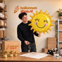 Jesse houdt de Zon Helium XL Ballon vast in de warme inpakruimte van Ballonnenshop.nl.