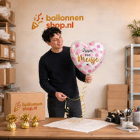 Jesse houdt de Jippie Een Meisje Helium Ballon vast in de warme werkplaats van Ballonnenshop.nl.