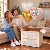 Een feestelijk huwelijksmoment met Just Married Hartjes Trosje boven een open Speciaal voor jou-doos in een warme woonkamer.