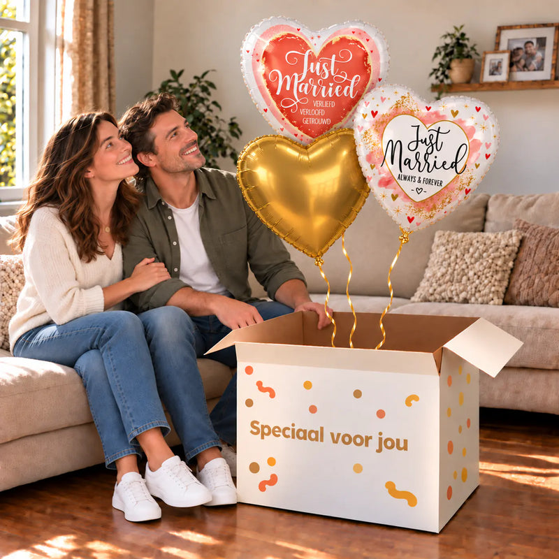 Een feestelijk huwelijksmoment met Just Married Trosje Ballonnen boven een open Speciaal voor jou-doos in een warme woonkamer.