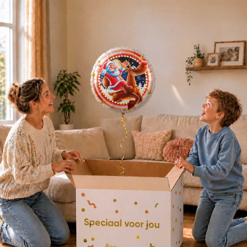 Moeder en zoon bekijken een Kerstman op Rendier heliumballon van 46 cm boven een geopende cadeaudoos.