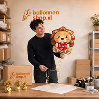 Jesse houdt de Leeuw I Love You Ballon vast in de warme werkplaats van Ballonnenshop.nl.