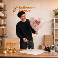 Jesse houdt de Liefste Mama Helium Ballon vast in de warme werkplaats van Ballonnenshop.nl.