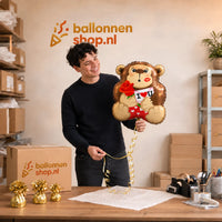 Jesse houdt de Love Gorilla Ballon vast in de warme werkplaats van Ballonnenshop.nl.