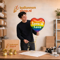 Jesse houdt de Love Is Love Helium Ballon vast in de warme werkplaats van Ballonnenshop.nl.