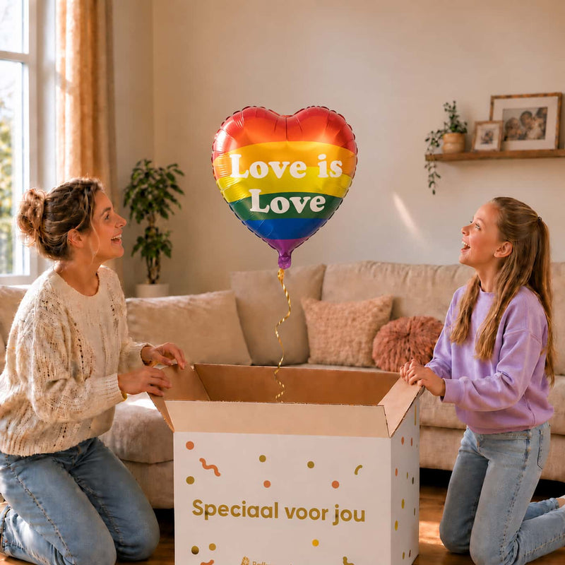Moeder en meisje pakken een regenboogkleurige Love is Love hartballon van 43 cm uit een cadeaudoos.