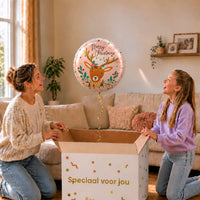 Moeder en meisje pakken een Merry Christmas rendierballon van 46 cm uit een cadeaudoos.