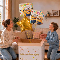 Minion Verjaardags Trosje Geel/Wit/Goud: moeder en zoon pakken het heliumgevulde ballonnentrosje uit een Speciaal voor jou-doos, met natuurlijk gekrulde gouden linten.