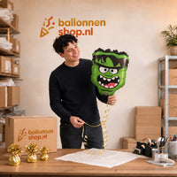 Jesse houdt de Monster Helium Ballon vast in de warme werkplaats van Ballonnenshop.nl.